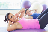 Fit women doing pilate exercises in fitness studio