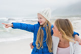 Girl showing something to mother at beach