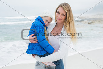 Young woman carrying little girl at beach