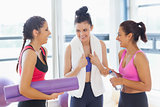 Three fit young women chatting in exercise room
