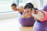 Portrait of two fit women exercising on fitness balls
