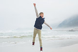 Full length of a casual boy jumping at beach