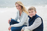 Casual woman and son relaxing at beach