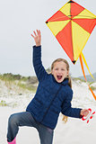 Cheerful young girl with kite at beach