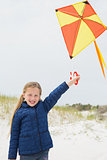 Portrait of a smiling girl with kite at beach