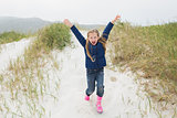 Full length of a cheerful girl running at beach