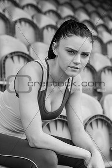 Serious toned woman sitting on chair in the stadium