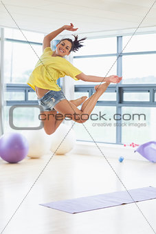 Young woman jumping in fitness studio