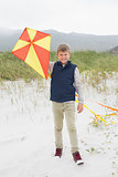 Portrait of a happy boy with kite at beach