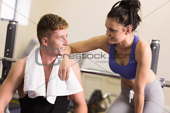 Sporty man and woman chatting in gym