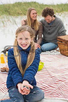 Happy family of three at a beach picnic