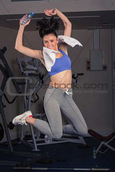 Full length portrait of fit woman jumping in gym