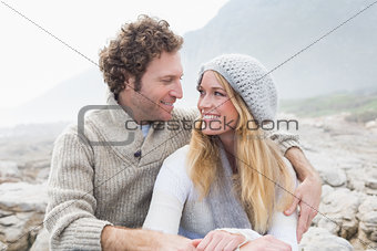 Happy couple sitting together on rocky landscape