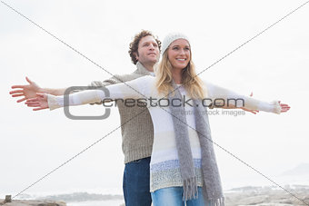 Happy casual young couple stretching hands out