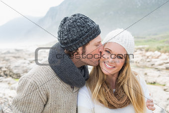 Man kissing a woman on rocky landscape