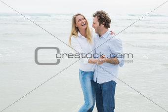 Cheerful couple dancing at beach