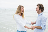 Cheerful couple looking at each other at beach
