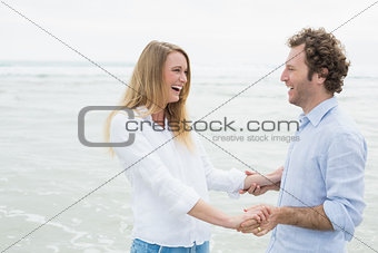 Cheerful couple looking at each other at beach