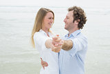 Happy young couple dancing at beach