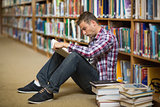 Student sitting on library floor reading