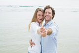 Portrait of cheerful couple dancing at beach
