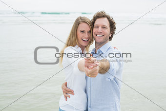 Portrait of cheerful couple dancing at beach