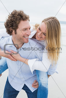 Man piggybacking woman at beach