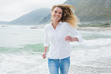 Portrait of a smiling woman running at beach