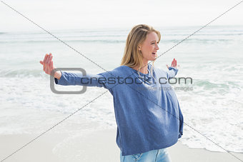 Woman standing with arms outstretched at beach