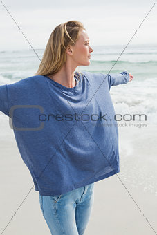 Woman with arms outstretched at beach