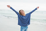 Happy woman with hands raised at beach