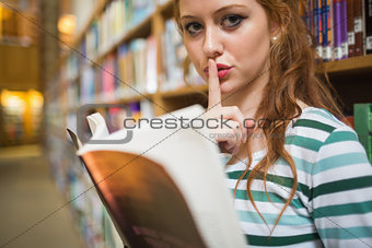 Serious student asking for silence holding a book