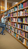 Redhead student taking a book from bookshelf in the library