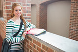 Redhead student smiling at camera in the corridor