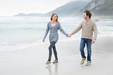 Couple holding hands and walking at beach