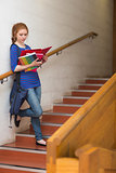 Redhead serious student reading notes on the stairs