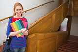 Student standing on the stairs smiling at camera