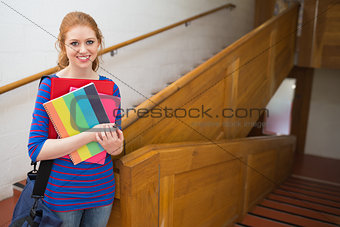 Student standing on the stairs smiling at camera