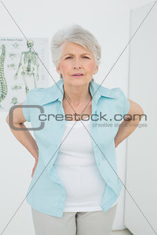 Senior woman with back pain in medical office