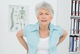 Senior woman with back pain in medical office