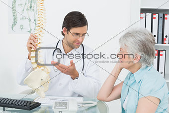 Male doctor explaining the spine to a senior patient