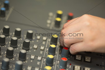 Hand working on a sound mixing desk