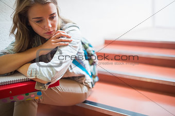 Sad lonely student sitting on stairs