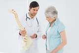 Doctor explaining the spine to a senior patient