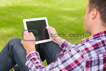 Happy student using his tablet outside