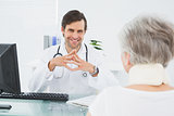 Smiling doctor listening to senior patient at medical office