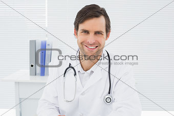 Smiling confident male doctor in medical office