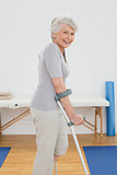 Side view of a smiling senior woman with crutches