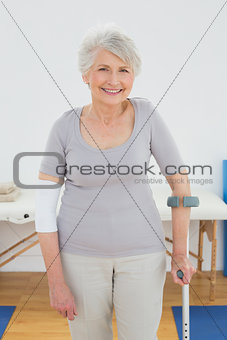 Portrait of a smiling senior woman with crutch