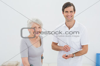 Smiling male therapist and disabled senior patient
